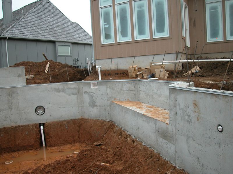 Bare concrete pool shell with a formed swimout bench