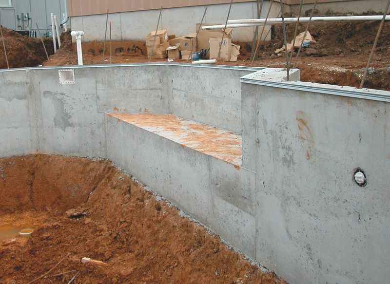 Stripped concrete pool wall with a formed swimout bench