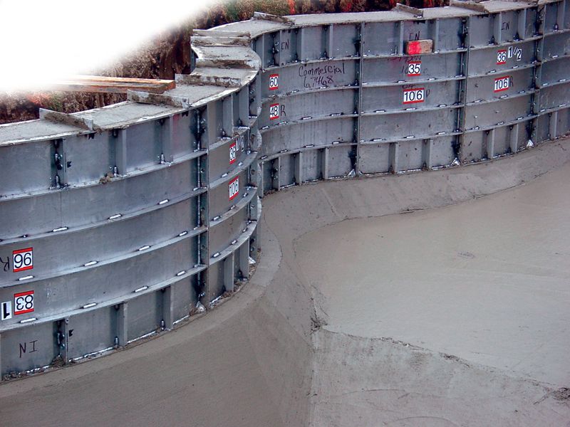 Curved aluminum pool wall forms standing on a poured footing