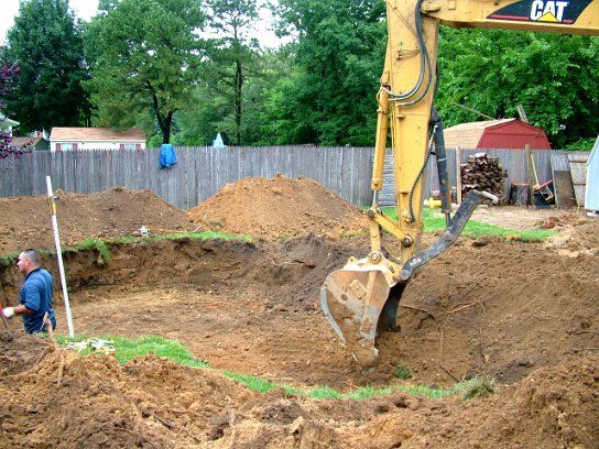 Excavator digging the pool area in a back yard