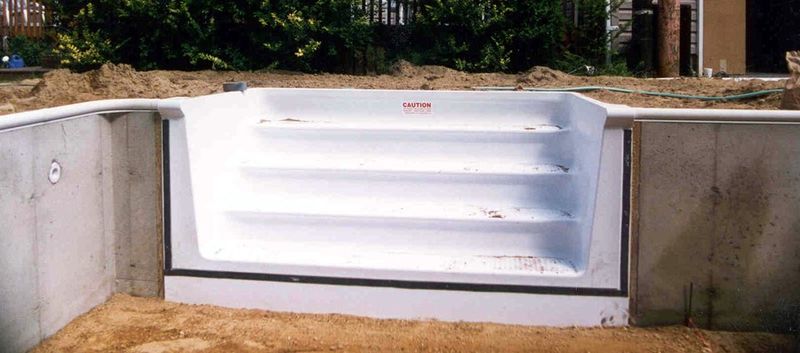 Fiberglass step unit set into a poured concrete pool wall