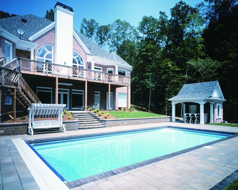 Finished rectangular in-ground pool with a paver deck