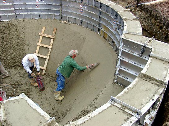 Crew finishing the concrete floor of the pool by hand