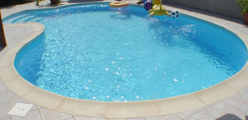 Kidney-shaped concrete pool filled with water