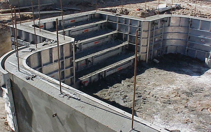Aluminum step forms set into a pool wall before the pour