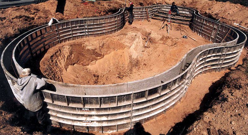 Radius forms set for a kidney-shaped pool, with a crew member checking the wall