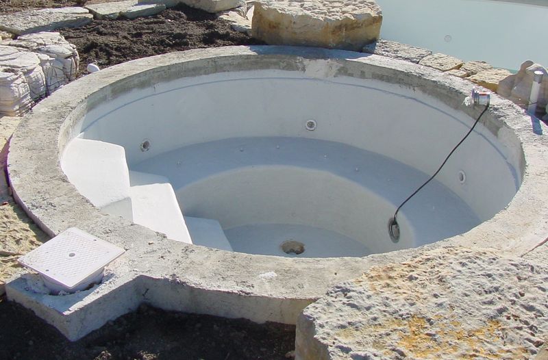 Round concrete spa shell with a stone surround