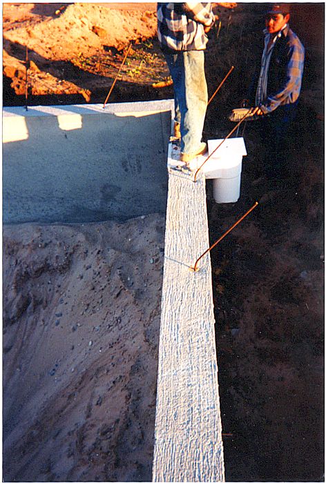 View down a formed pool wall with a block-out where the skimmer will be set