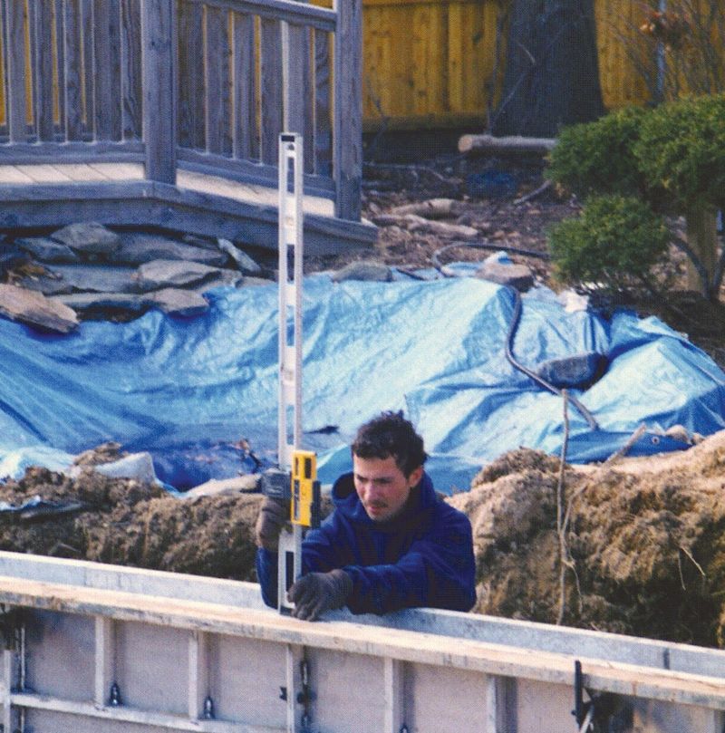 Crew member leveling the top of the pool forms