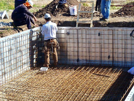 Crew tying a grid of reinforcing steel inside the exterior forms