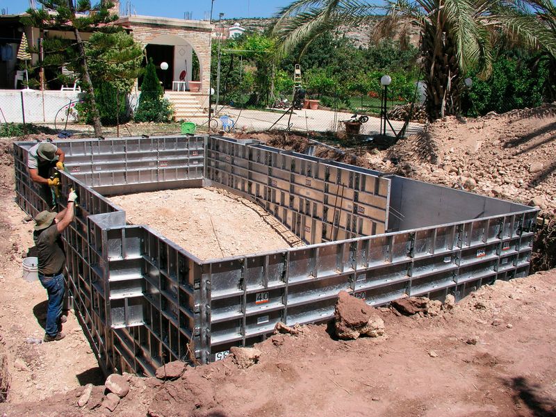 Straight wall aluminum pool forms being set on a jobsite