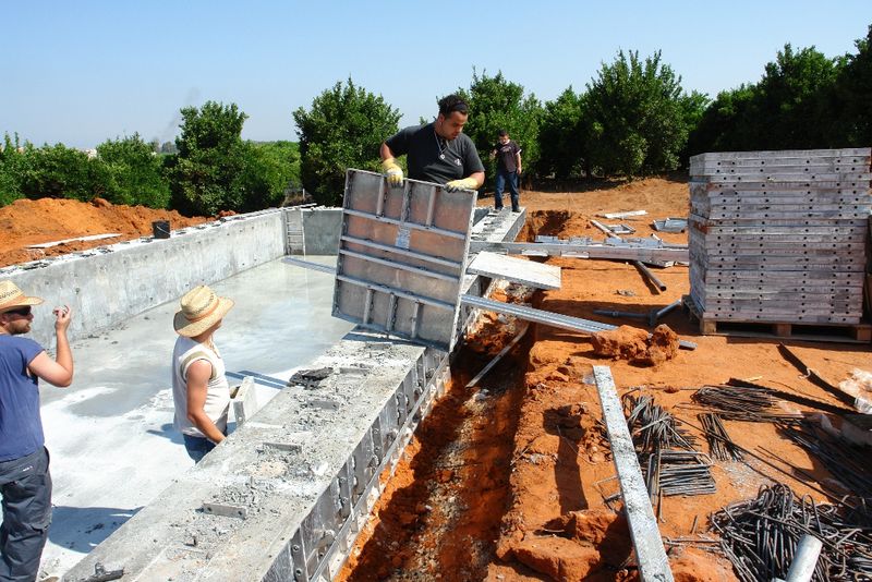 Crew working inside a rectangular pool formed with straight wall aluminum forms