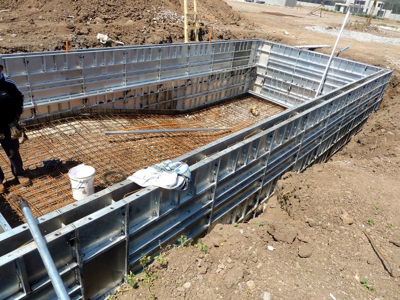 Straight wall forms set around a rectangular pool with reinforcing steel on the floor