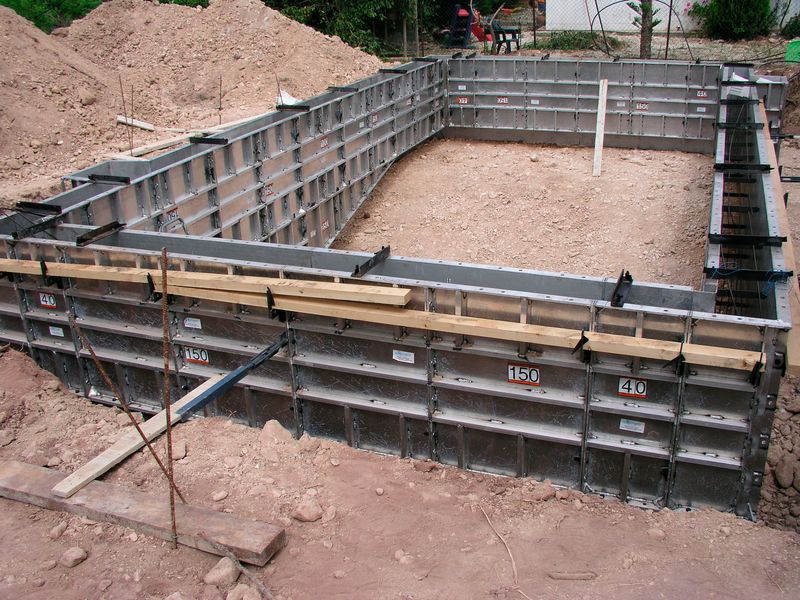 Straight wall aluminum pool forms set, pinned and braced around a rectangular pool