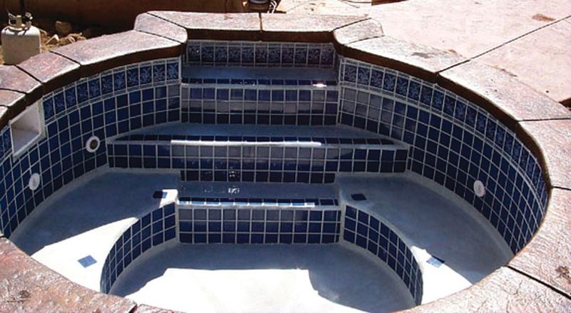 Finished concrete spa lined in blue tile